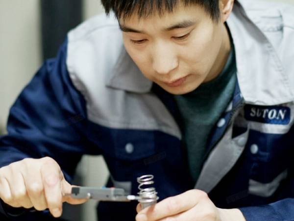 A quality inspector is testing product carefully.